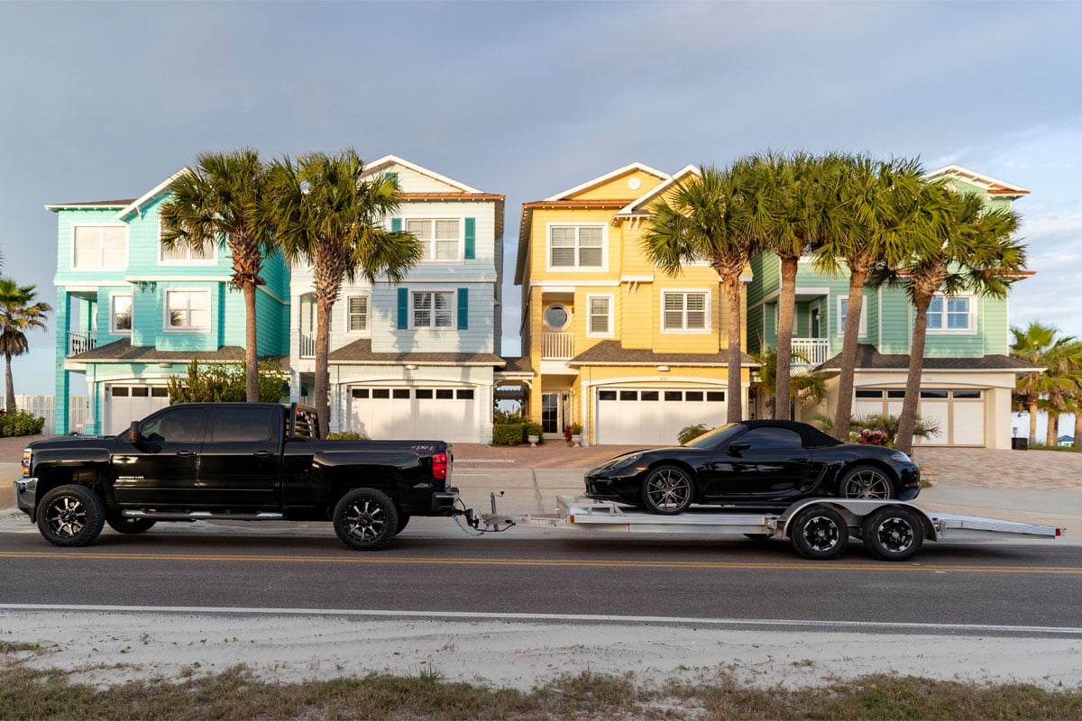 Black Truck Hauling Black Car On CargoPro Open Car Hauler